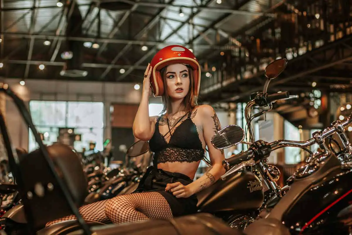 Buyers Guide - Frau auf einem Motorrad probiert einen Helm